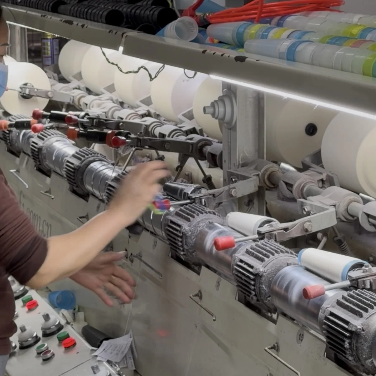 Interior of a BSCI-certified knitwear factory in Shantou with rows of computerized flat knitting machines in operation