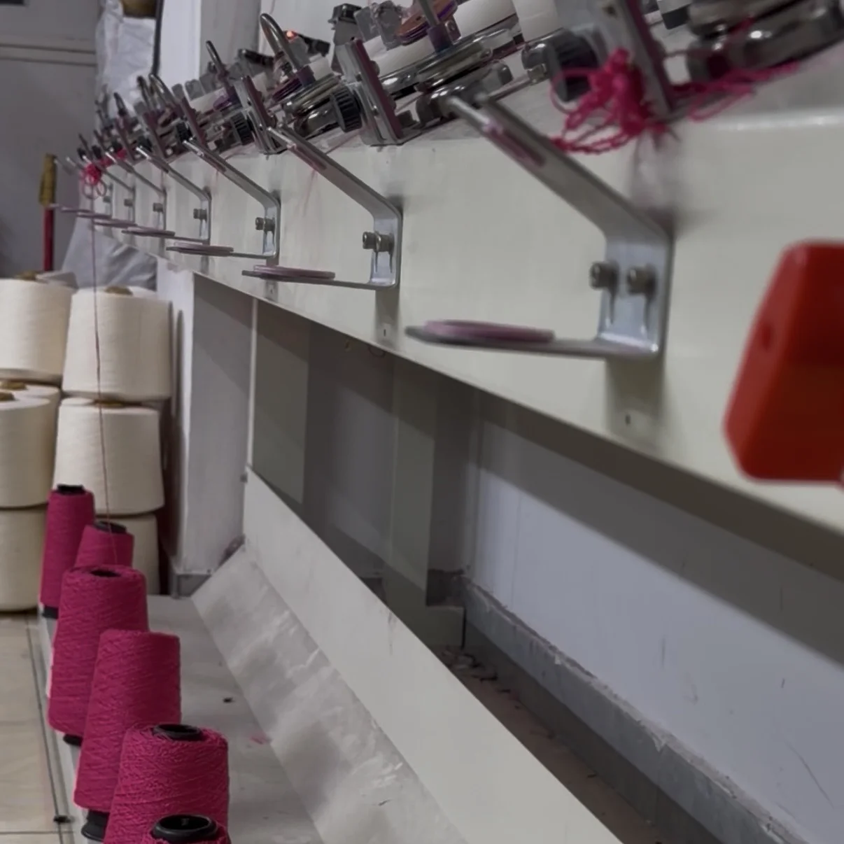 Skilled factory workers operating computerized flat knitting machines in a BSCI-certified Shantou knitwear production facility