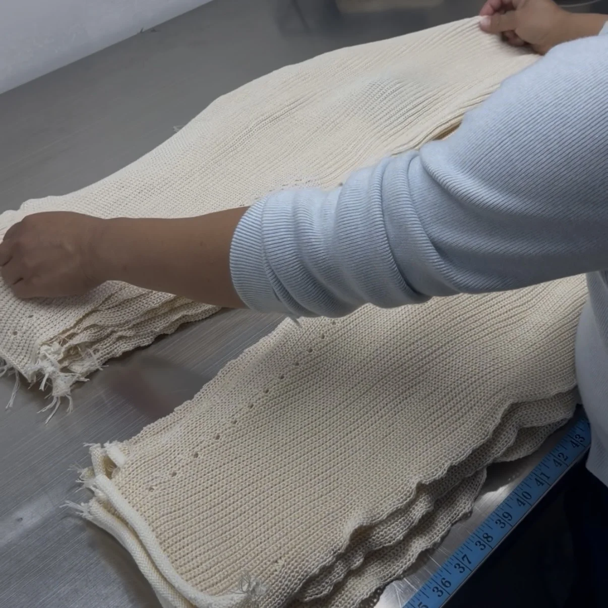 Well-organized workshop environment in a Shantou knitwear factory with knitting machines and material storage
